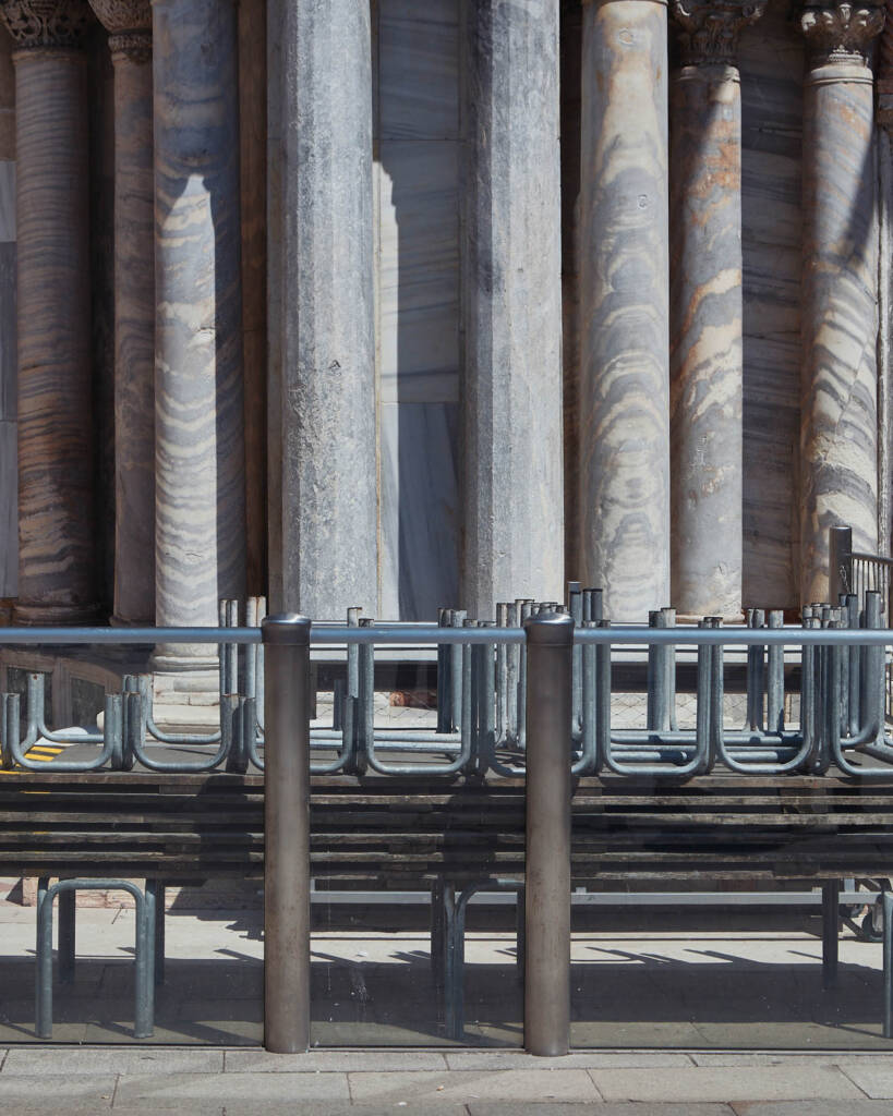 File di barriere metalliche installate alla base delle colonne di un portico veneziano
